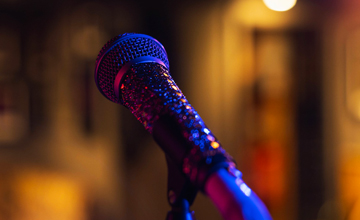 Zdjęcie mikrofon w odcieniach fioletu na rozmazanym tle ze światłami